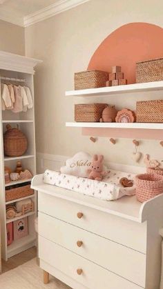 a baby's nursery room with white furniture and pink accessories on the shelves, including a crib