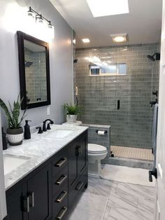 a bathroom with two sinks, a toilet and a walk in shower