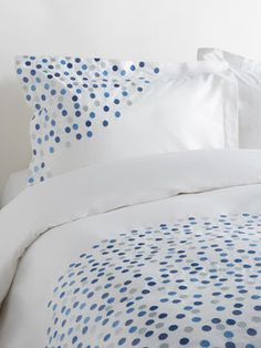 a bed with white and blue polka dots on it