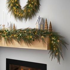 a mantel decorated with pine cones and christmas lights