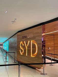 there is a sign that says departures and the name syd in front of it