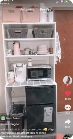 a microwave oven sitting on top of a white shelf next to a black and white stove