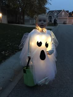 a little boy dressed up in a ghost costume