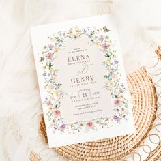 a wedding card with flowers on it sitting next to a wicker basket and lace