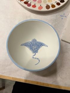 a blue and white bowl sitting on top of a table next to a painting palette