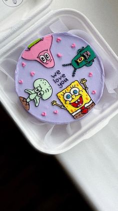 a cake in a plastic container with spongebob characters on it