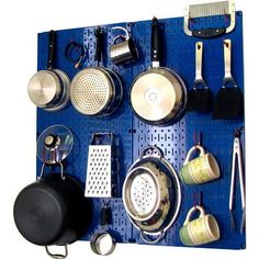 a blue peg board with pots and pans on it