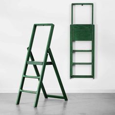 a green ladder leaning against a white wall next to a wooden steplade in an empty room