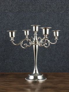 a silver candelabra sitting on top of a wooden table