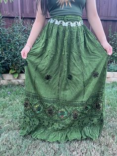 Introducing our Pari Vintage Vibe Green Embroidery Maxi Skirt, perfect for embracing those boho hippie vibes! This stunning skirt features a pleated border that adds a touch of elegance, while the maxi length offers a chic and comfortable fit. Crafted with fairycore fashion in mind, this skirt is ideal for creating enchanting cottage-core looks. Whether you're strolling along sandy shores or exploring hideaways, this skirt will ensure you're dressed to impress. Its flowing silhouette captures th Green Hippie Maxi Skirt For Festival, Fitted Peasant Style Festival Skirt, Festival Tiered Skirt Dress With Lined Skirt, Fitted Peasant Skirt For Festival, Festival Dresses With Lined Tiered Skirt, Tiered Skirt Dress With Lined Skirt For Festivals, Bohemian Festival Dress With Lined Skirt, Bohemian Skirted Dresses For Festivals, Summer Festival Skirt With Floral Embroidery