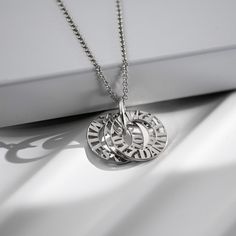 Tokens of Love Necklace - Silver | Oak & Luna Elegant Sterling Silver Name Necklaces, Elegant Sterling Silver Necklaces With Names, Silver Sterling Silver Name Necklace For Anniversary, Silver Sterling Silver Name Necklace For Anniversary Gift, Silver Sterling Name Necklace For Anniversary, Elegant Silver Nickel-free Name Necklace, Sterling Silver Name Necklace For Anniversary, Meaningful Silver Stainless Steel Necklace, Sterling Silver Engraved Charm Necklaces For Anniversary Gift