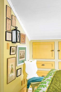 a bedroom with yellow walls and pictures on the wall