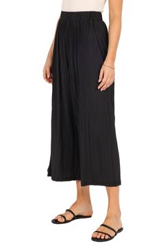 These flowy, culotte-style pants have an elastic waist and pleated design so you move with ease every day whether you're going out or enjoying a day at home. Elastic waist Unlined 100% polyester Hand wash, dry flat Imported Black Summer Pants For Daywear, Chic Pleated Bottoms For Vacation, Versatile Relaxed Fit Culottes With Elastic Waistband, Casual Black Flowy Bottoms, Black Wide Leg Bottoms For Daywear, Black Wide-leg Bottoms For Daywear, Chic Black Wide Leg Pants For Daywear, Flowy Rayon Bottoms For Day Out, Solid Pleated Beach Bottoms