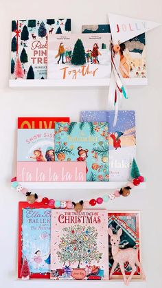 three books are hanging on the wall with christmas cards attached to each bookcases