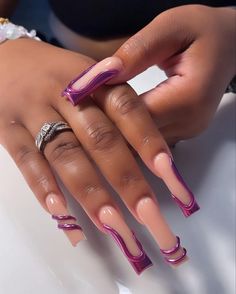 a woman's hand with pink and purple nail designs on it, holding onto her manicured nails