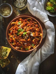 a bowl filled with pasta and sauce next to other dishes