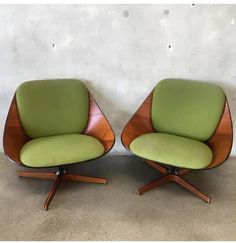 pair of mid century modern lounge chairs in green upholstered fabric and walnut wood