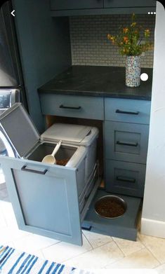 a dog bowl is in the bottom drawer of a kitchen cabinet that's open