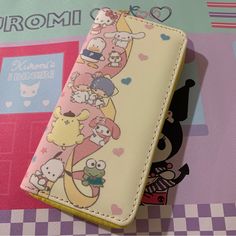 a wallet with cartoon characters on it sitting on top of a checkered tablecloth