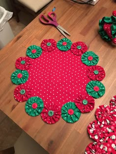 a wooden table topped with lots of red and green decorations