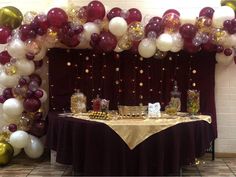 a table topped with lots of balloons and confetti on it's sides