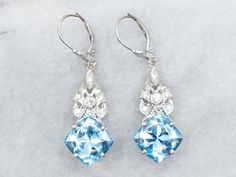 These stunning white gold drop earrings are sure to make a splash! Their shimmering blue topaz stones and diamond accents give them a look that's both dazzling and daring. Treat yourself to glitz and glamour--you deserve it! Metal: 14K White Gold Gem: 2 Blue Topaz totaling 14.40 Carats Gem Measurements: 10.7 mm, Square Cushion Cut Accents: Diamonds totaling .38 Carats, VS in Clarity, G-H in Color Measurements: 13.0 x 44.0 mm Marks: "14K:" Stamped on the findings SKU #: A30470 Each piece has been Luxury Light Blue Topaz Earrings, Anniversary Multi-stone Blue Topaz Earrings, Luxury Blue Topaz Drop Earrings, Elegant Blue Diamond-cut Earrings, White Gold Drop Earrings, Luxury Multi-stone Blue Topaz Earrings, Blue Topaz Stone, Blue Topaz Earrings, Topaz Earrings