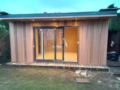 a small wooden shed with sliding glass doors