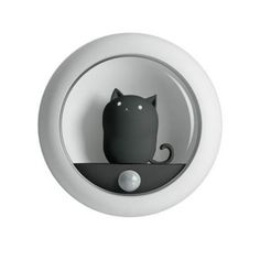 a black cat sitting on top of a white wall mounted light with its head turned to the side