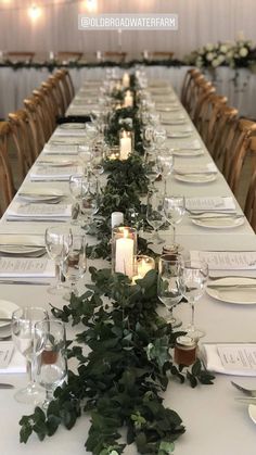 the long table is set with candles and greenery for an elegant dinner or party