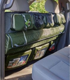 the back seat of a car with luggage in it's cargo compartment and trees in the background