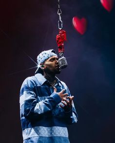 a man in blue jacket holding onto a red object with chains hanging from it's mouth