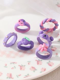 purple and pink rings are on a plate next to other items in the shape of animals