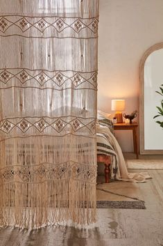 a room with a bed, rugs and curtains on the floor in front of a window