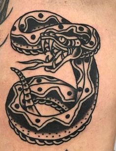 a black and white snake tattoo on the back of a man's upper arm