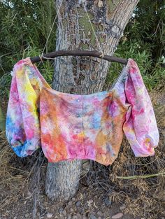 a colorful shirt is hanging on a tree