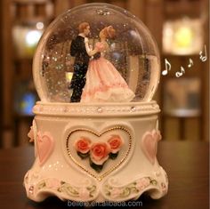 there is a snow globe with a bride and groom in it on top of a table