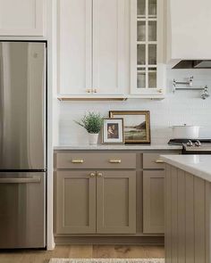 a kitchen with white cabinets and silver appliances