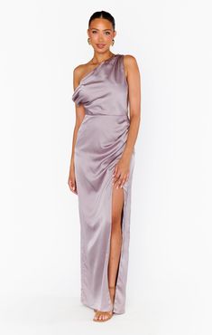 a woman wearing a purple dress with one side slited up and the other side split down