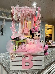 minnie mouse stuffed animal sitting on top of a wooden crate with pink tutu skirt