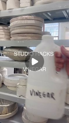 a person holding a jug in front of shelves filled with cheese