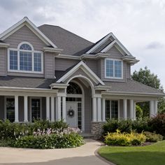 a large house with lots of windows and flowers in front of the entrance to it