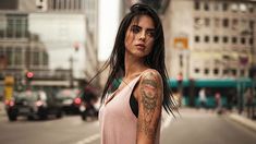 a woman with tattoos standing on the street