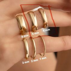 three different sizes of gold rings on someone's finger with measurements for each ring