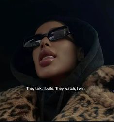 a woman wearing sunglasses and a leopard coat with the words they talk, i build they watch, i win