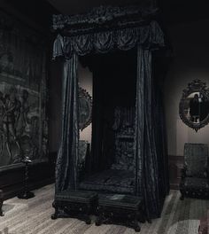 an ornate canopy bed in a room with tapestry on the wall and chair next to it