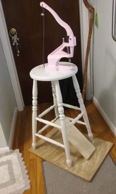 a white stool with a pink ironing board on top of it next to a door