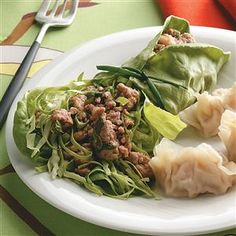 a white plate topped with meat and veggies on top of a green table