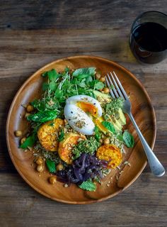 a wooden plate topped with salad and an egg