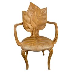 a chair made out of wood with a leaf design on the back and armrests