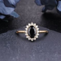 a black diamond ring sitting on top of a rock